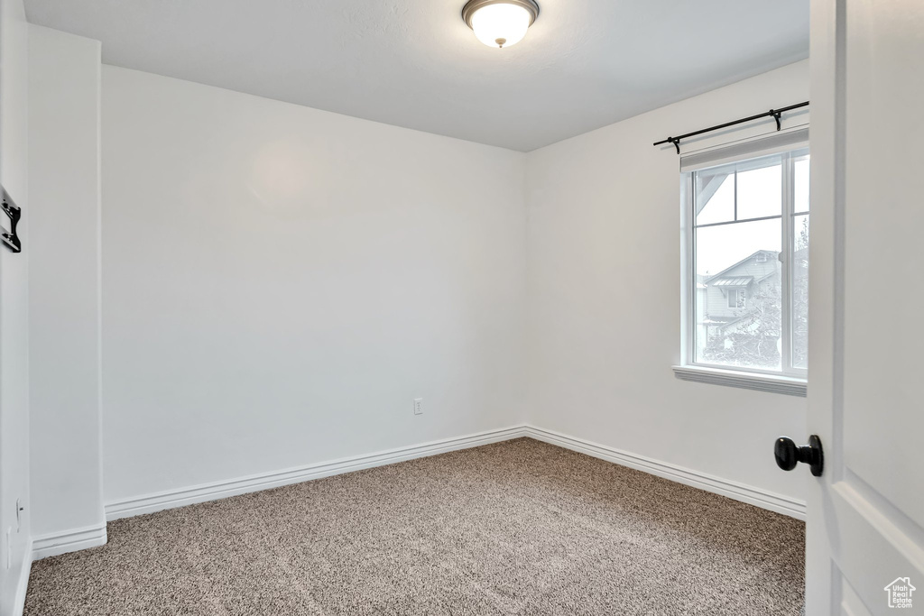Carpeted empty room featuring baseboards