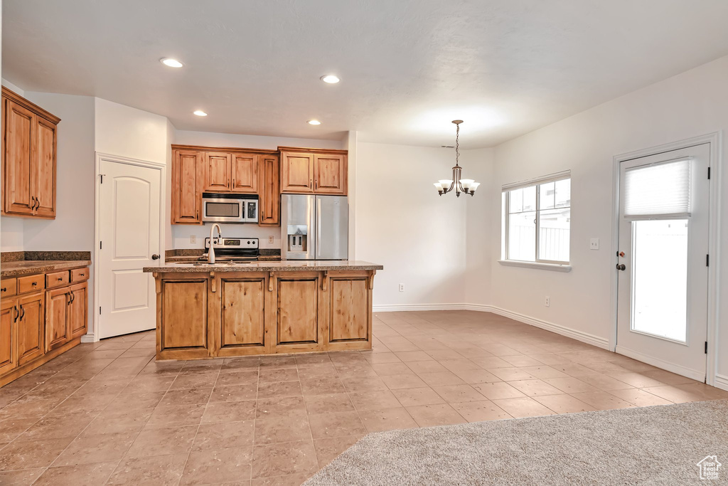 Kitchen featuring appliances with stainless steel finishes, a chandelier, a sink, recessed lighting, and an island with sink