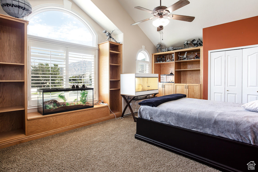 Bedroom featuring carpet floors, high vaulted ceiling, a closet, and ceiling fan