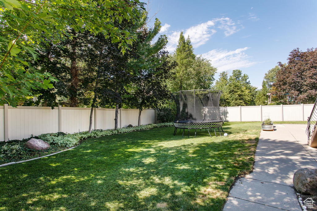 View of yard with a trampoline and a patio area