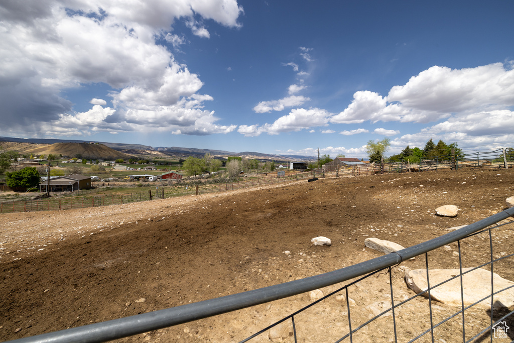 View of yard with a view of rural / pastoral area, an enclosed riding area, a mountain view, and fence