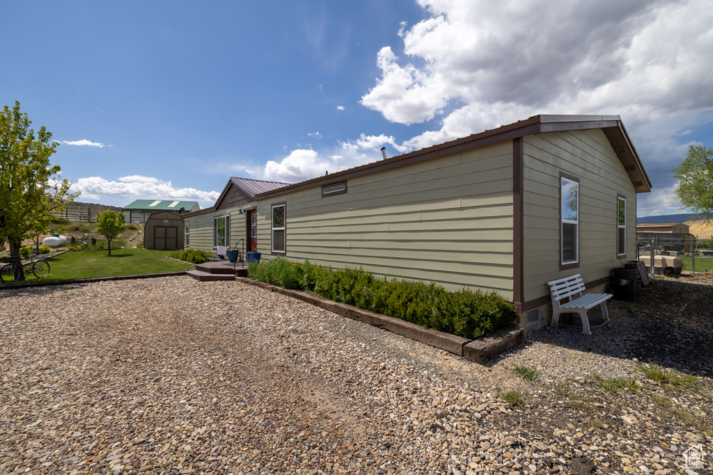 View of home\'s exterior featuring a storage shed, an outbuilding, and metal roof