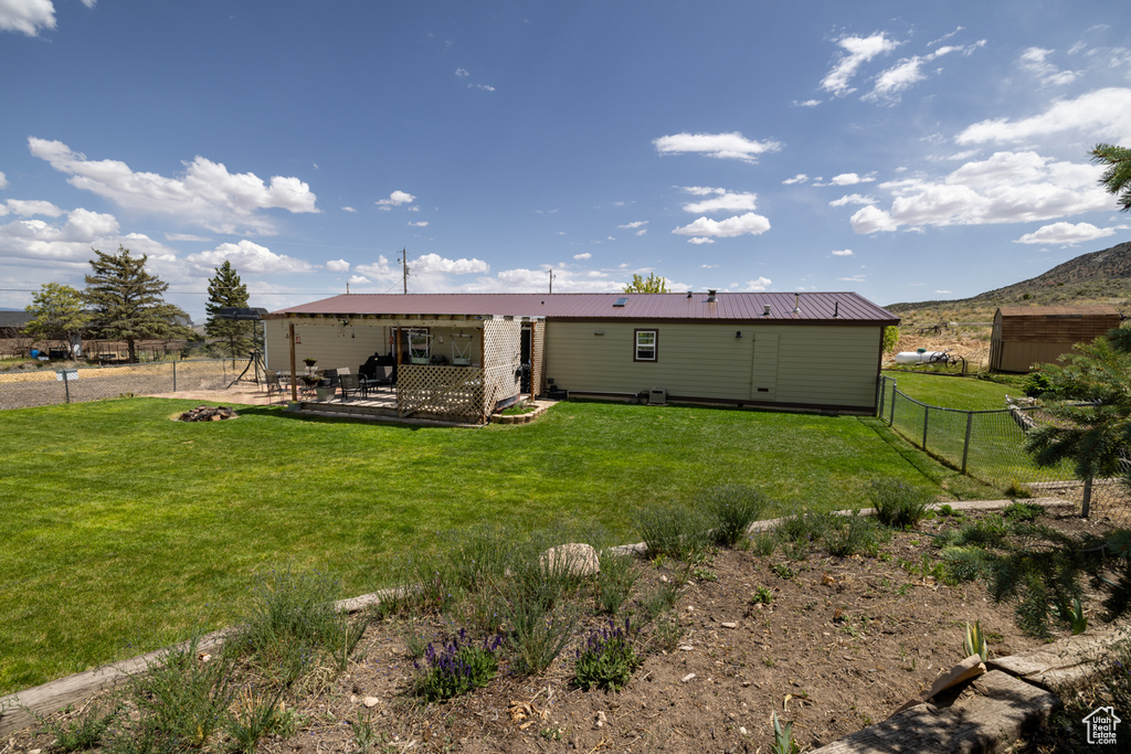 Rear view of house featuring metal roof and a patio