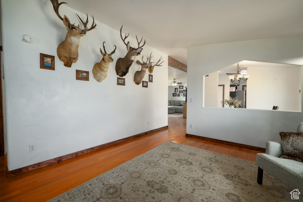 Sitting room featuring a chandelier, wood finished floors, and baseboards