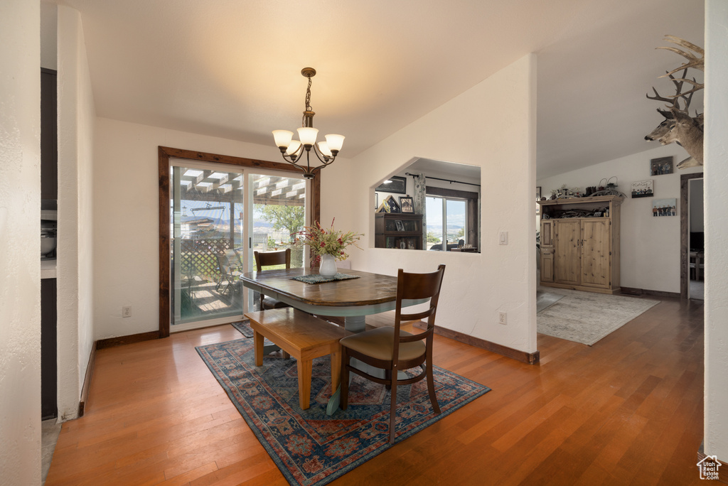 Dining space featuring a chandelier, wood finished floors, and baseboards