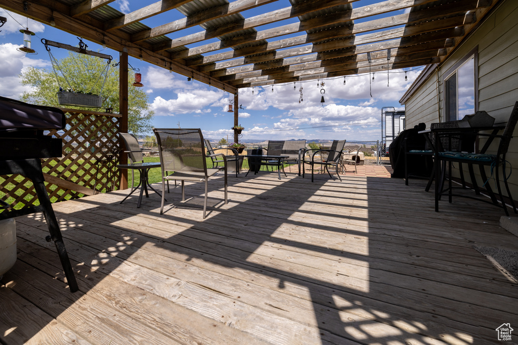 Wooden terrace with outdoor dining space and a pergola