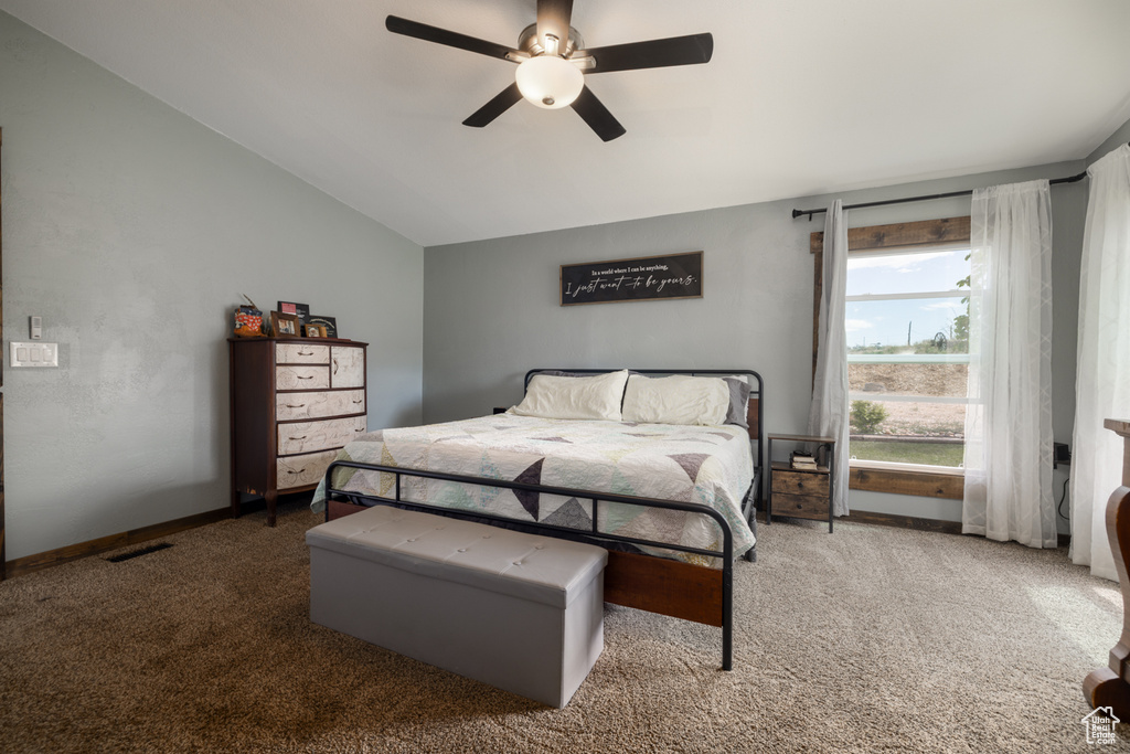 Carpeted bedroom featuring vaulted ceiling, ceiling fan, and baseboards