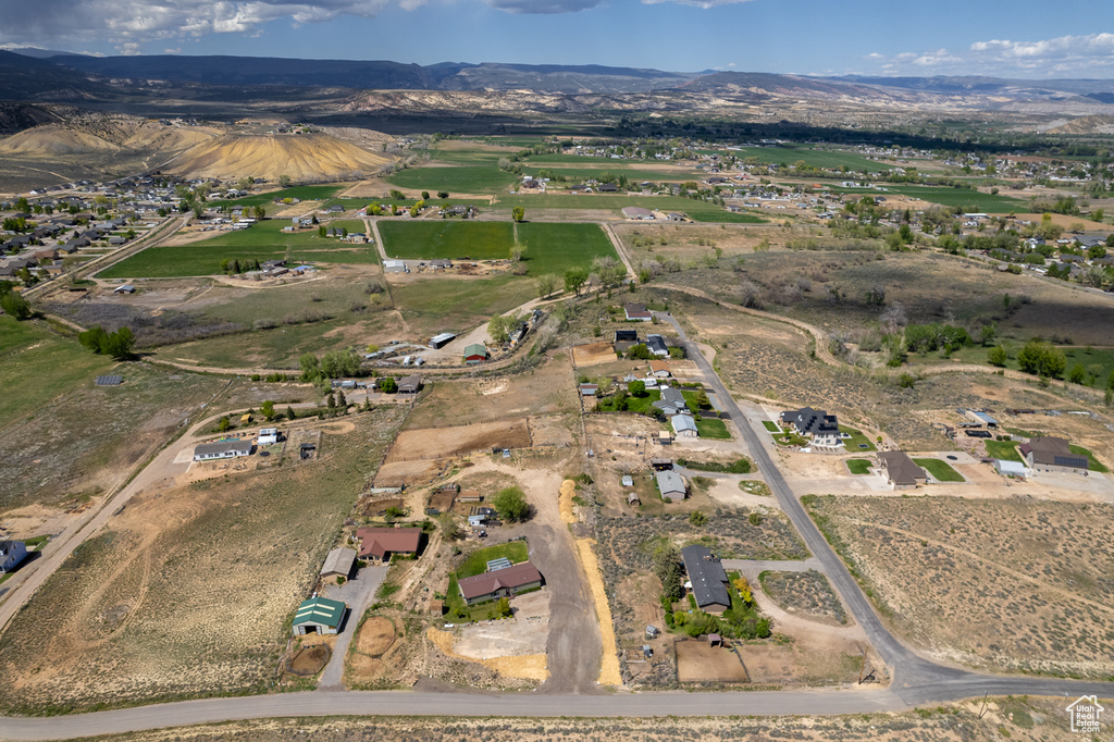 Aerial view of property and surrounding area featuring a mountainous background