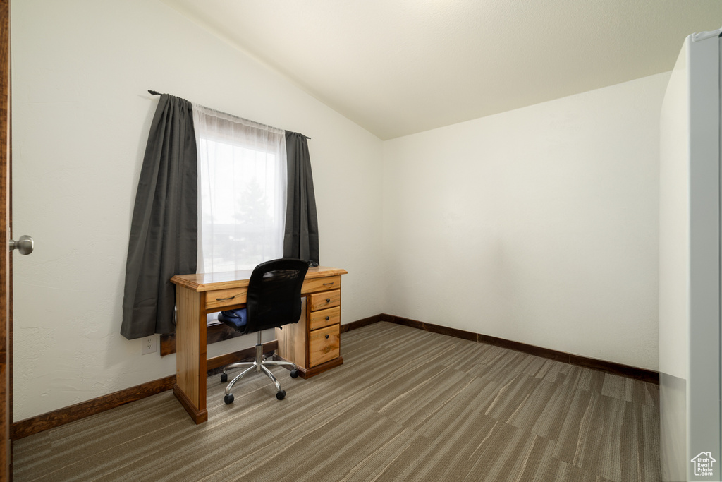 Office space with light carpet, lofted ceiling, and baseboards