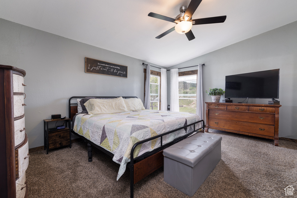 Carpeted bedroom with vaulted ceiling and ceiling fan