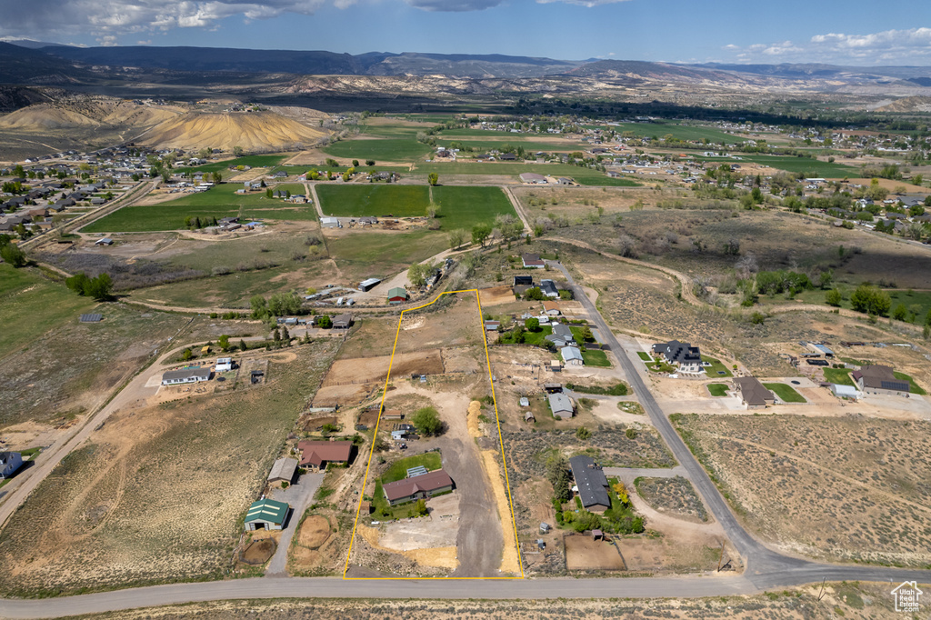 Aerial view of property and surrounding area with property parcel outlined and mountains