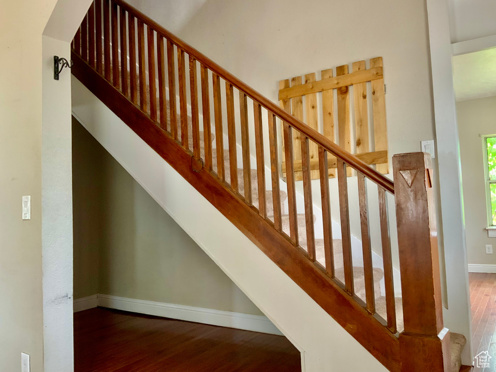 Stairway featuring wood finished floors and baseboards