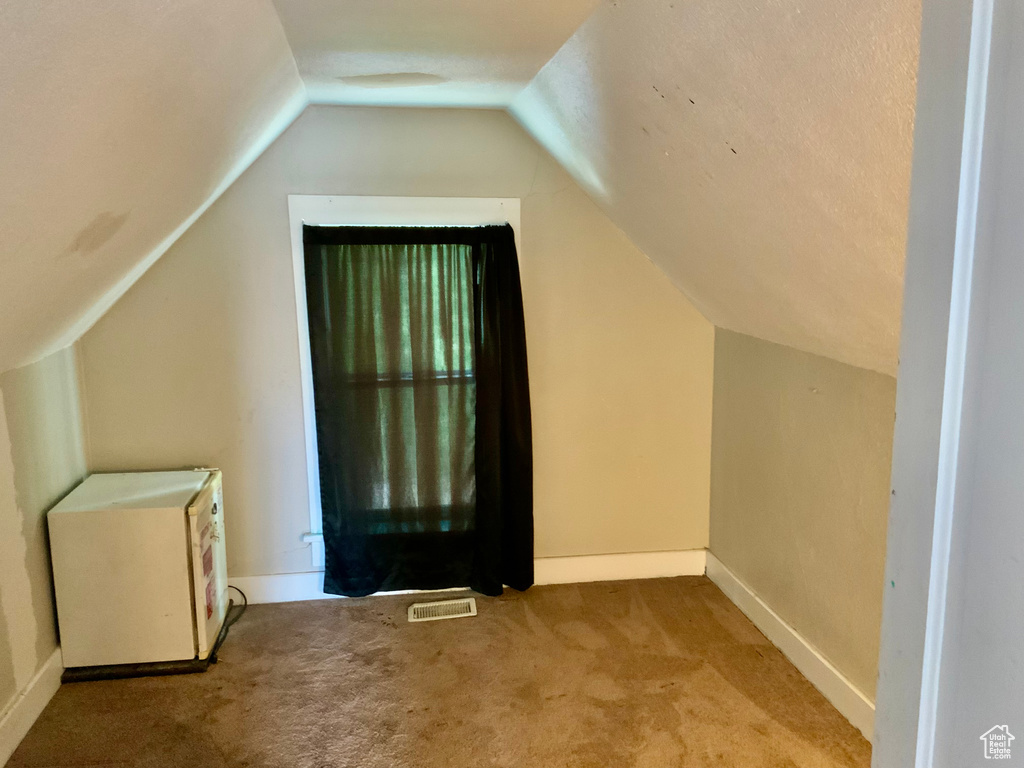 Bonus room featuring carpet, lofted ceiling, and baseboards