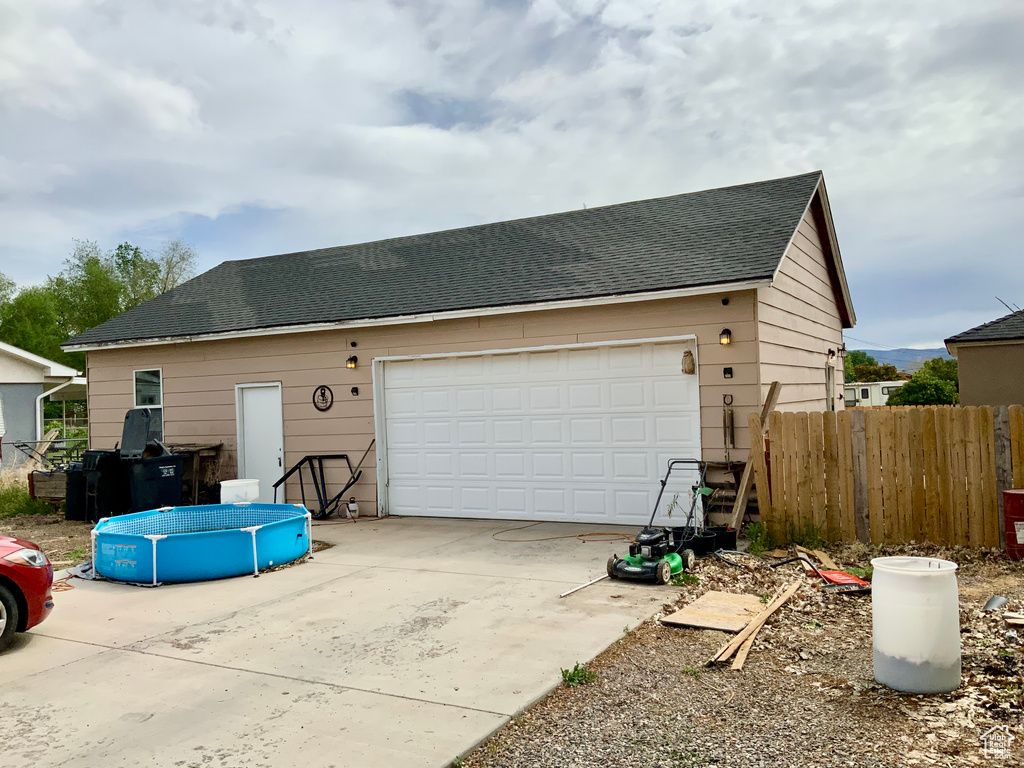 View of front of property featuring fence and roof with shingles