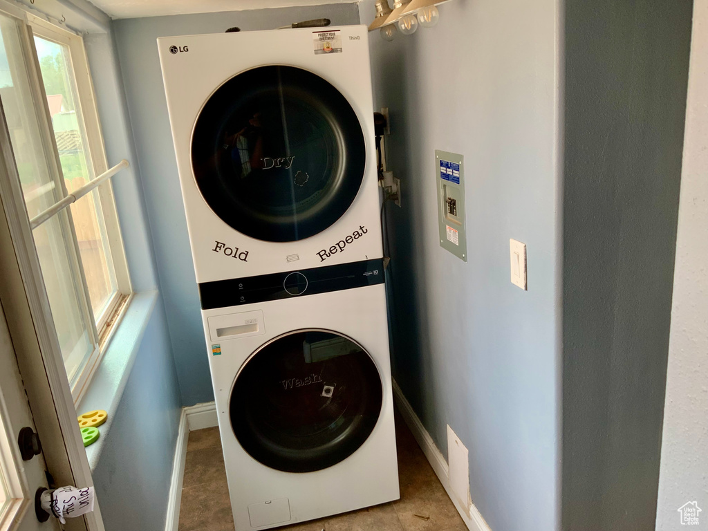 Laundry area featuring stacked washing machine and dryer and baseboards