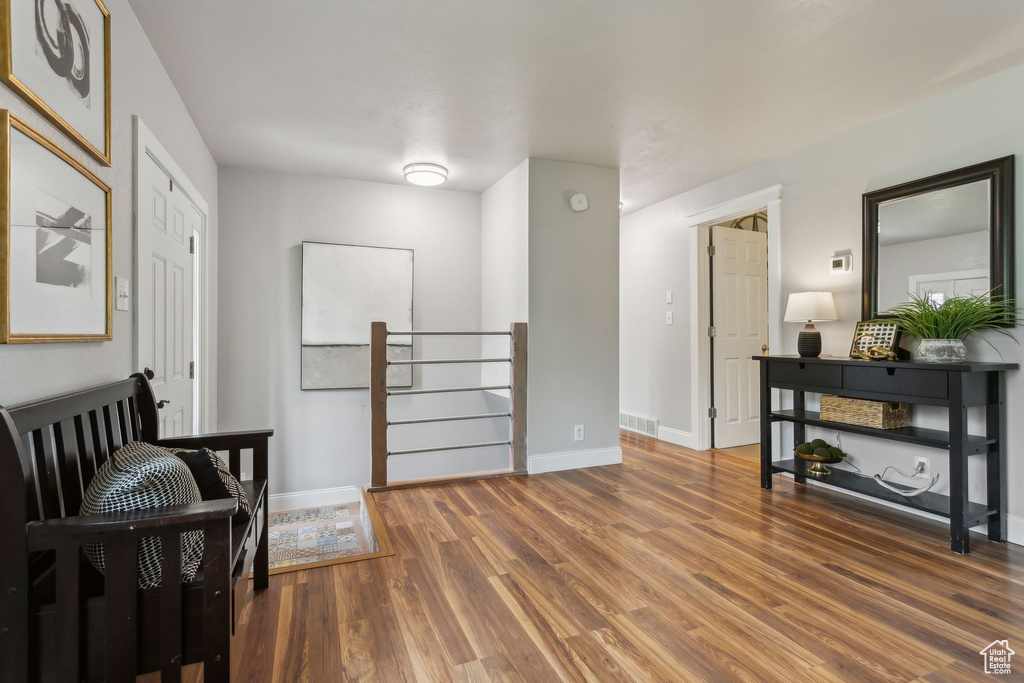 Living area with wood finished floors, an upstairs landing, and baseboards