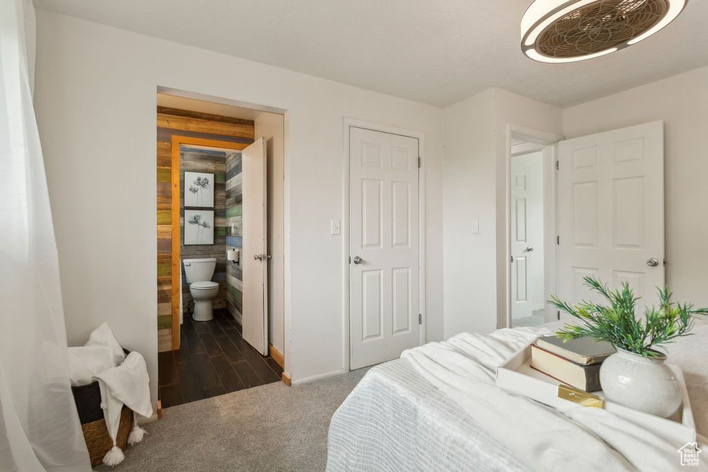Carpeted bedroom with connected bathroom and baseboards