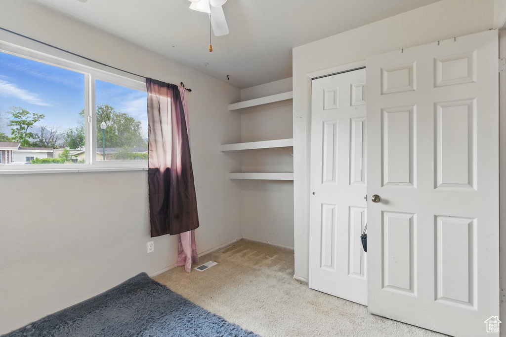 Unfurnished bedroom featuring carpet, a closet, and ceiling fan