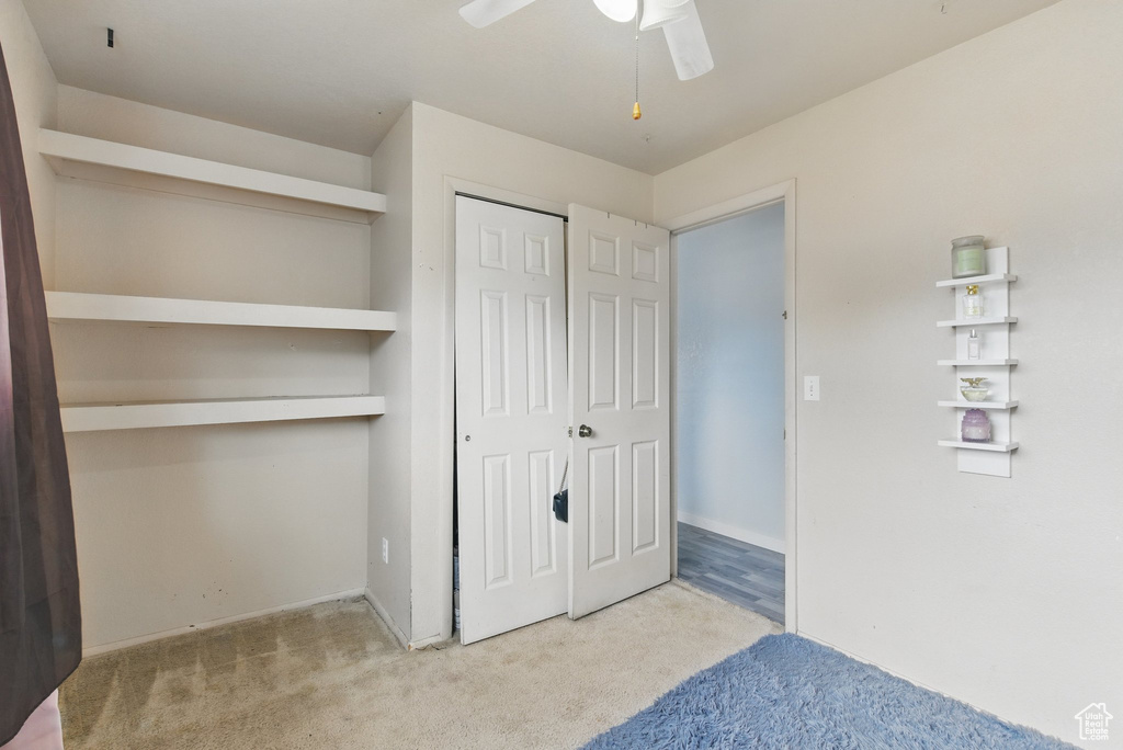 Unfurnished bedroom featuring carpet floors, a closet, and a ceiling fan