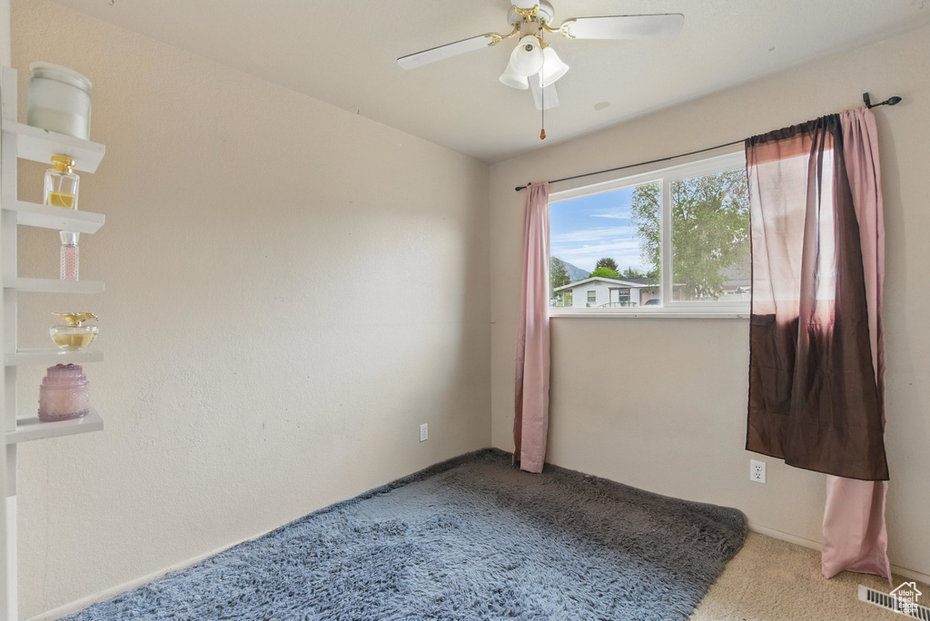 Spare room featuring carpet floors and ceiling fan