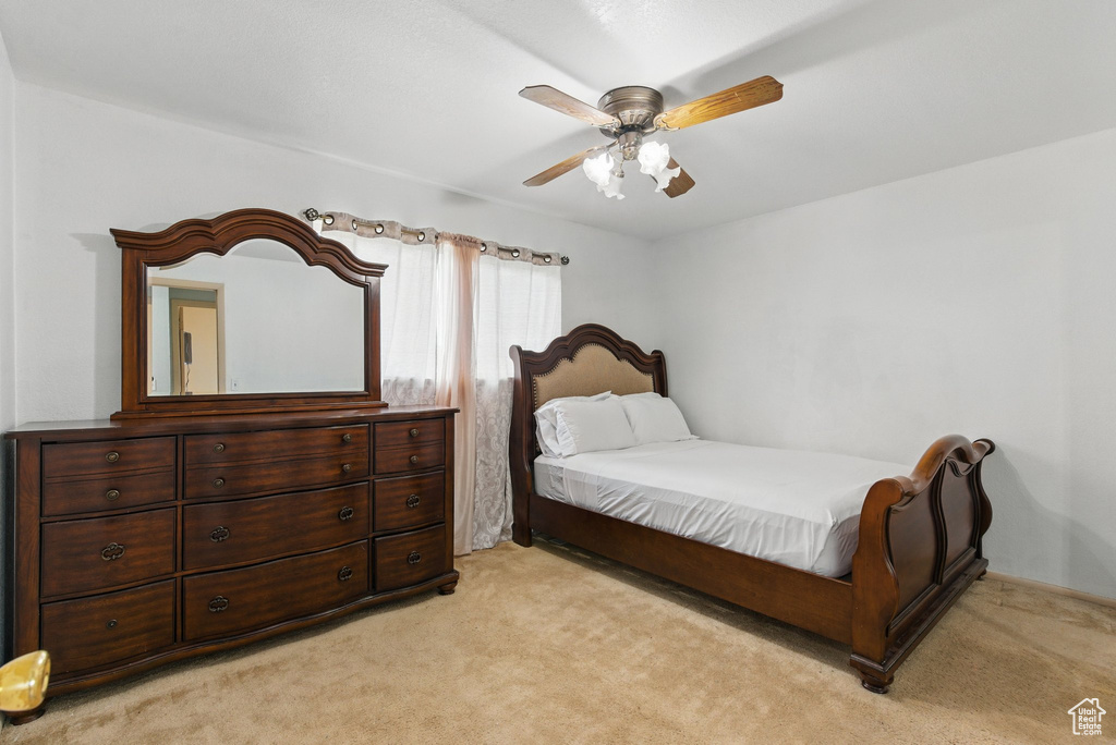 Bedroom with light colored carpet and a ceiling fan