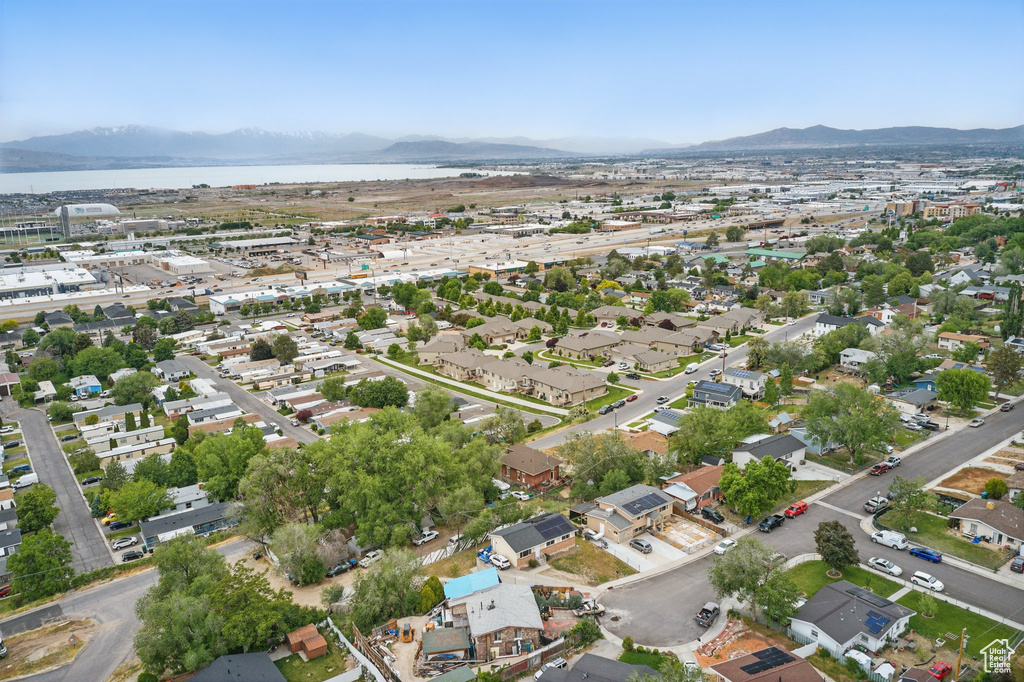 Aerial view of property and surrounding area featuring a water and mountain view and nearby suburban area