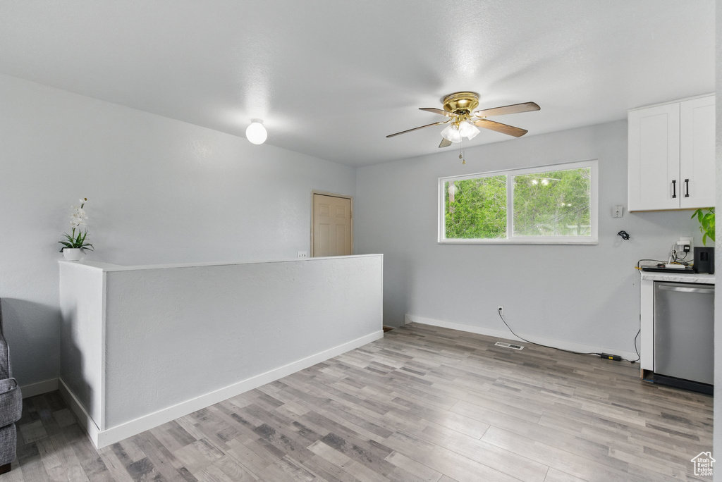 Kitchen featuring dishwasher, ceiling fan, light wood-type flooring, and white cabinetry