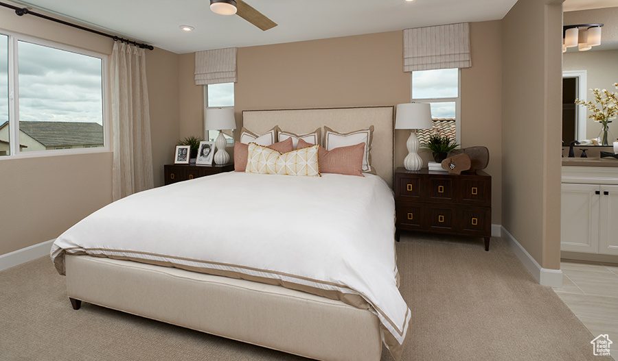 Bedroom with light colored carpet, baseboards, recessed lighting, ensuite bath, and a ceiling fan