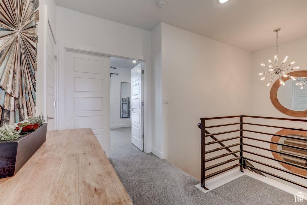 Hallway featuring an upstairs landing, carpet, a chandelier, and recessed lighting