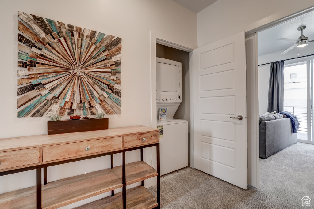 Washroom with stacked washer / dryer, carpet flooring, and ceiling fan