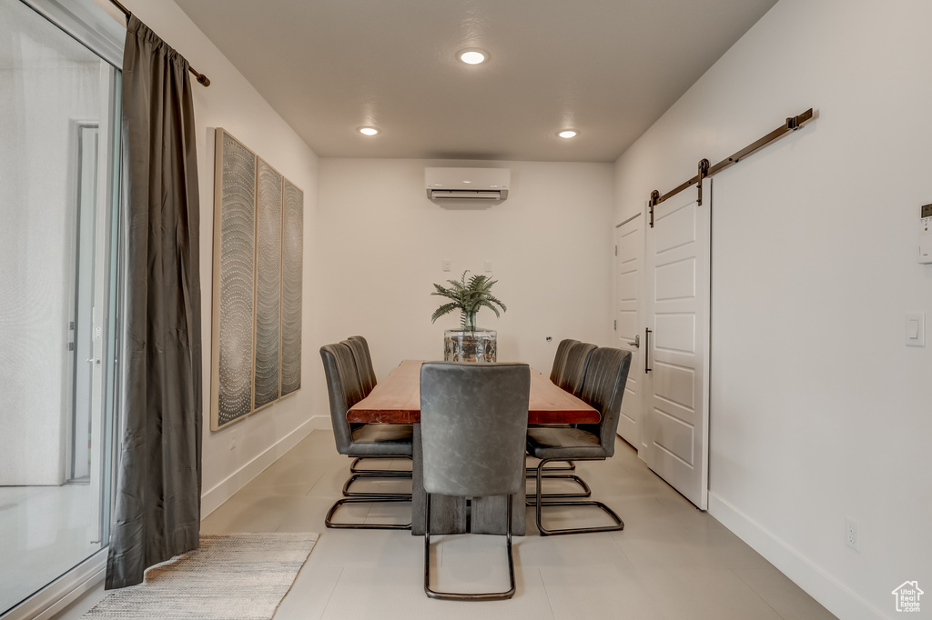 Dining space featuring a barn door, a wall mounted air conditioner, baseboards, and recessed lighting