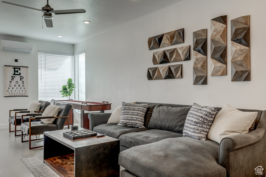 Living area with an AC wall unit, a ceiling fan, and recessed lighting