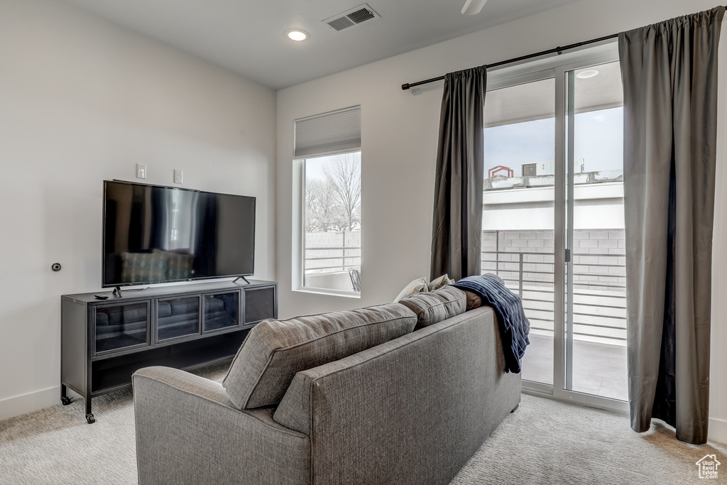 Living room with light colored carpet, recessed lighting, and baseboards