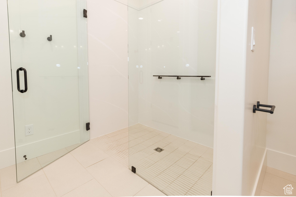 Full bath with a stall shower and tile patterned flooring
