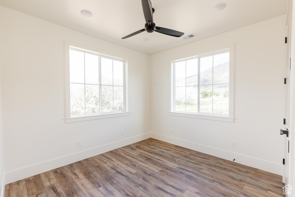 Unfurnished room featuring baseboards, wood finished floors, and ceiling fan