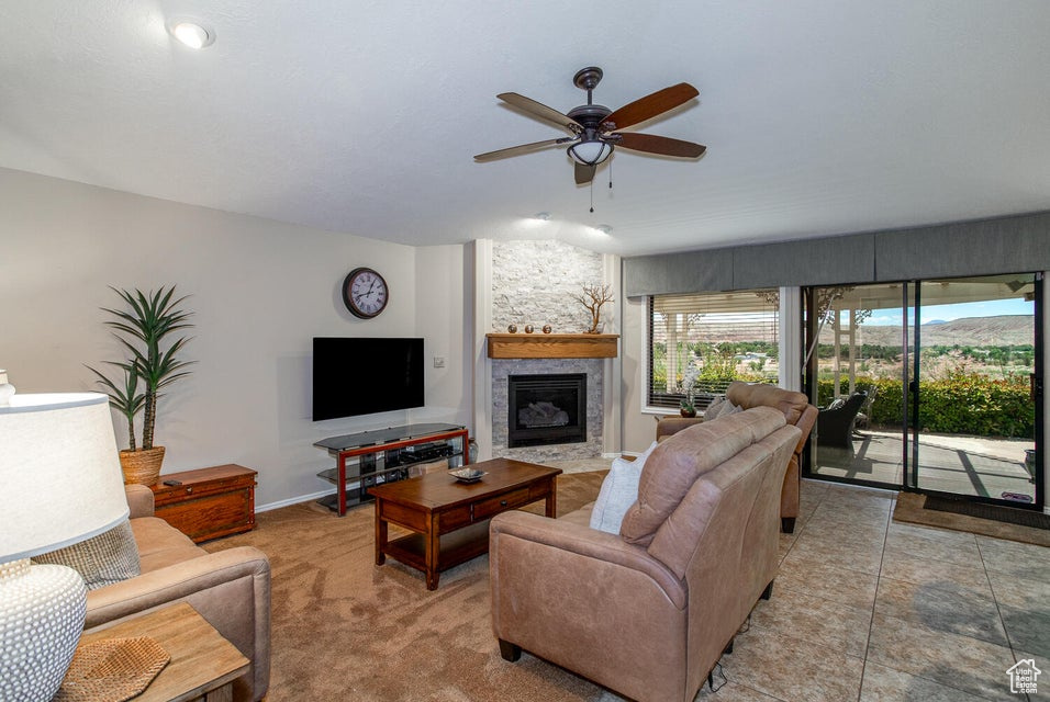 Living area with a fireplace and a ceiling fan
