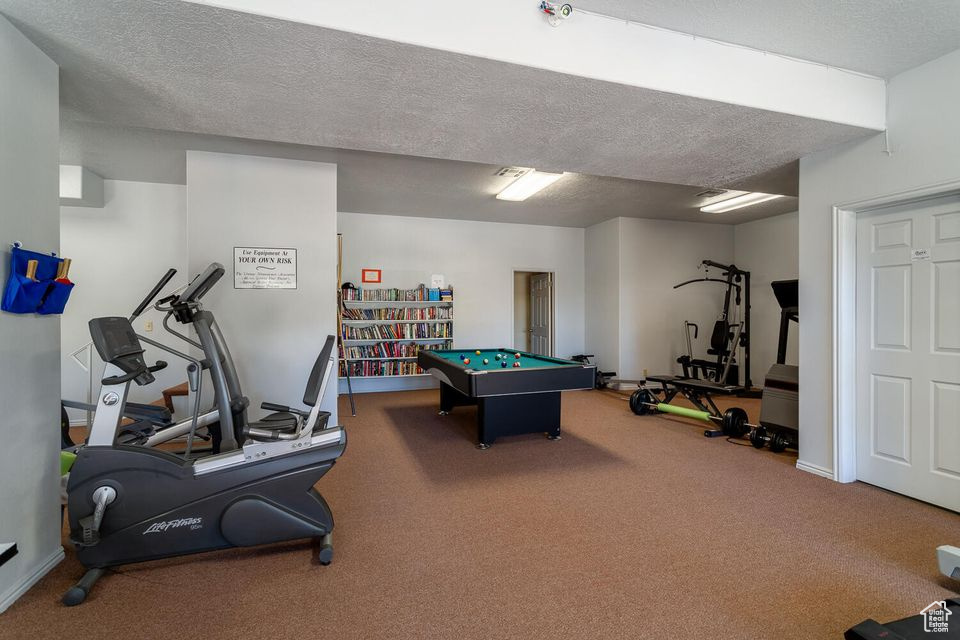 Rec room with carpet floors, a textured ceiling, and billiards
