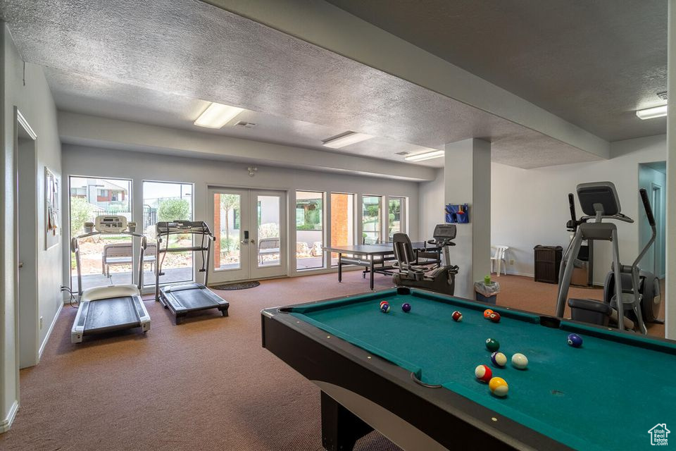 Rec room with a textured ceiling, carpet flooring, french doors, billiards table, and baseboards