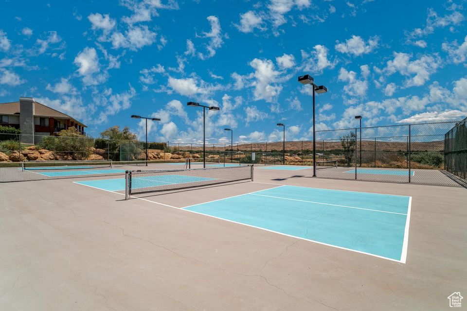 View of tennis court featuring fence and community basketball court