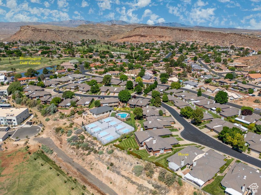 Aerial view of property and surrounding area with a mountainous background and nearby suburban area