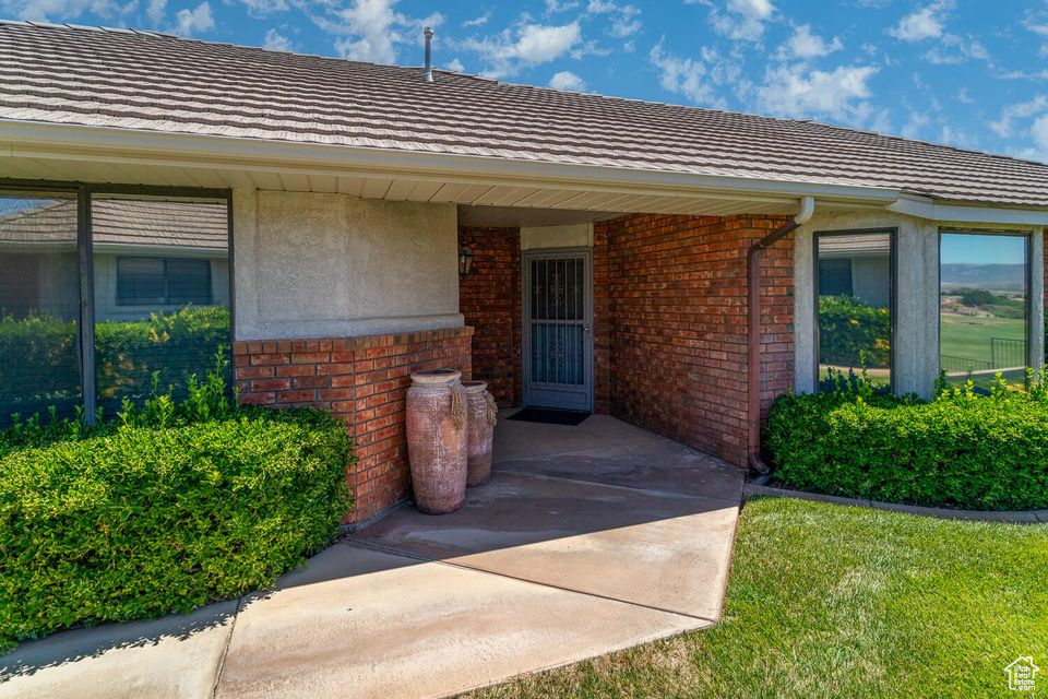 Doorway to property featuring brick siding