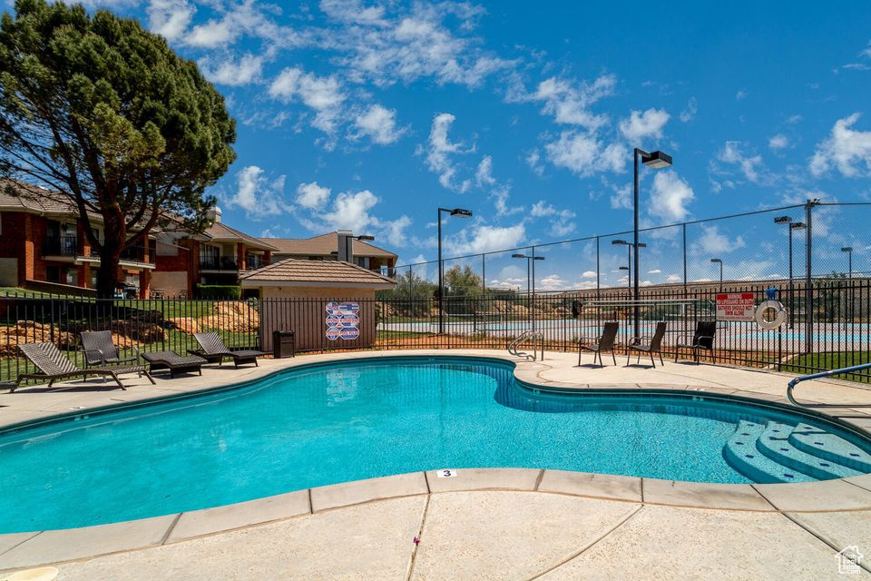 Community pool featuring fence and a patio