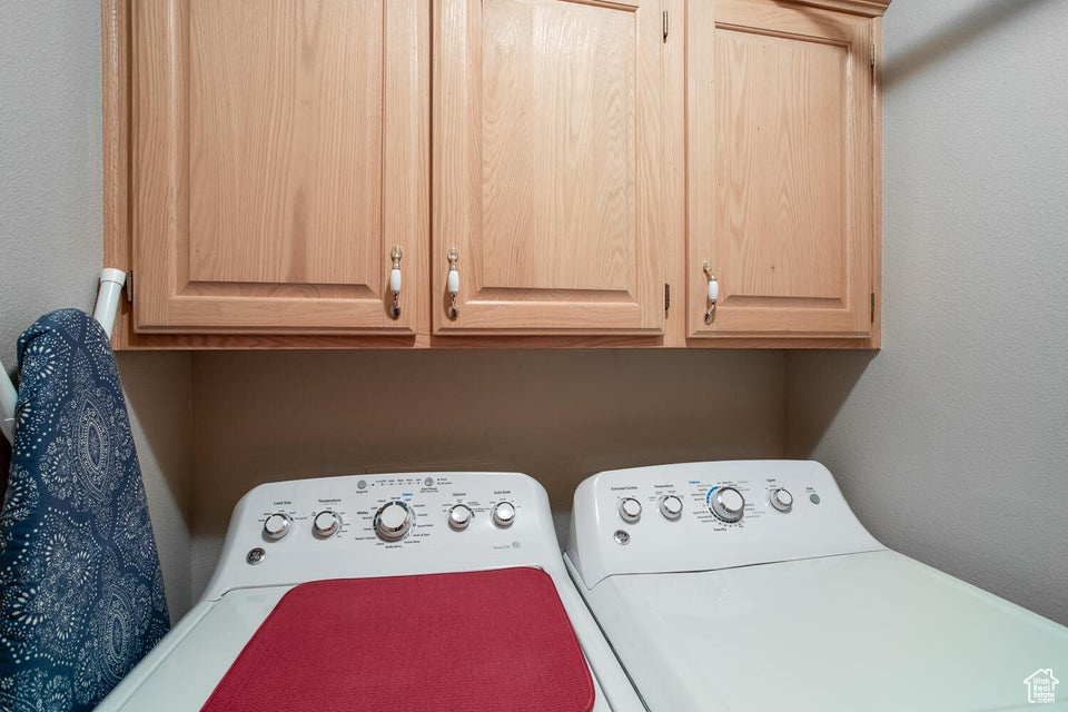 Clothes washing area with cabinet space and washer and clothes dryer
