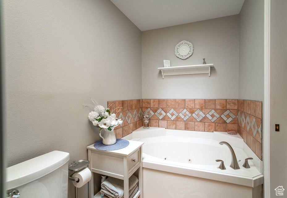 Bathroom with toilet and a jetted tub