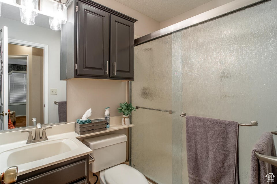 Bathroom with a shower stall, toilet, and vanity