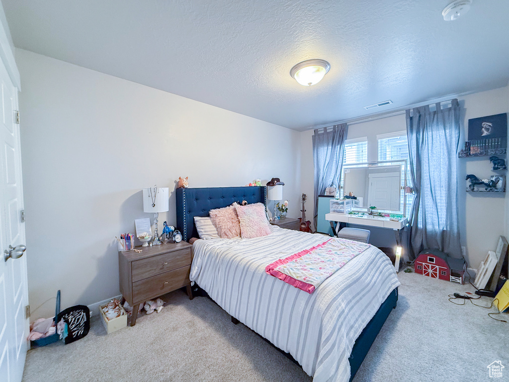 Bedroom featuring carpet and a textured ceiling