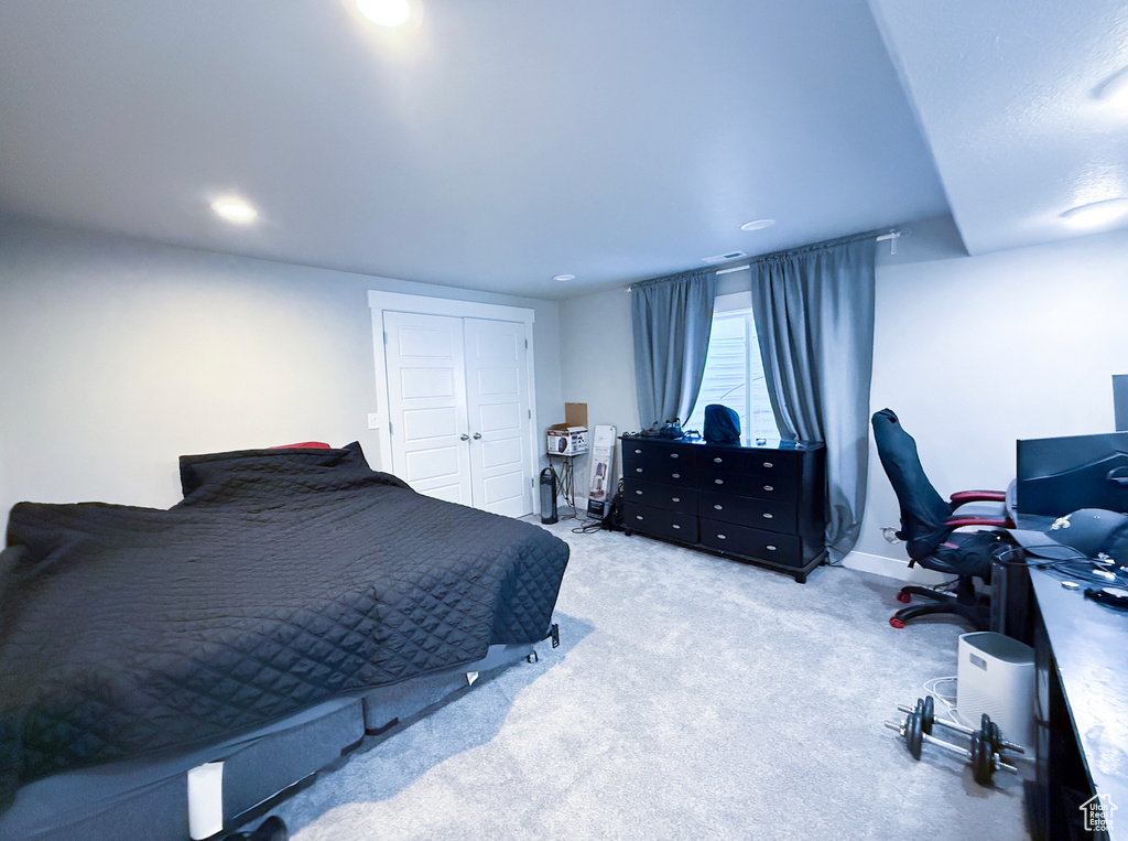 Carpeted bedroom with recessed lighting, baseboards, and a closet
