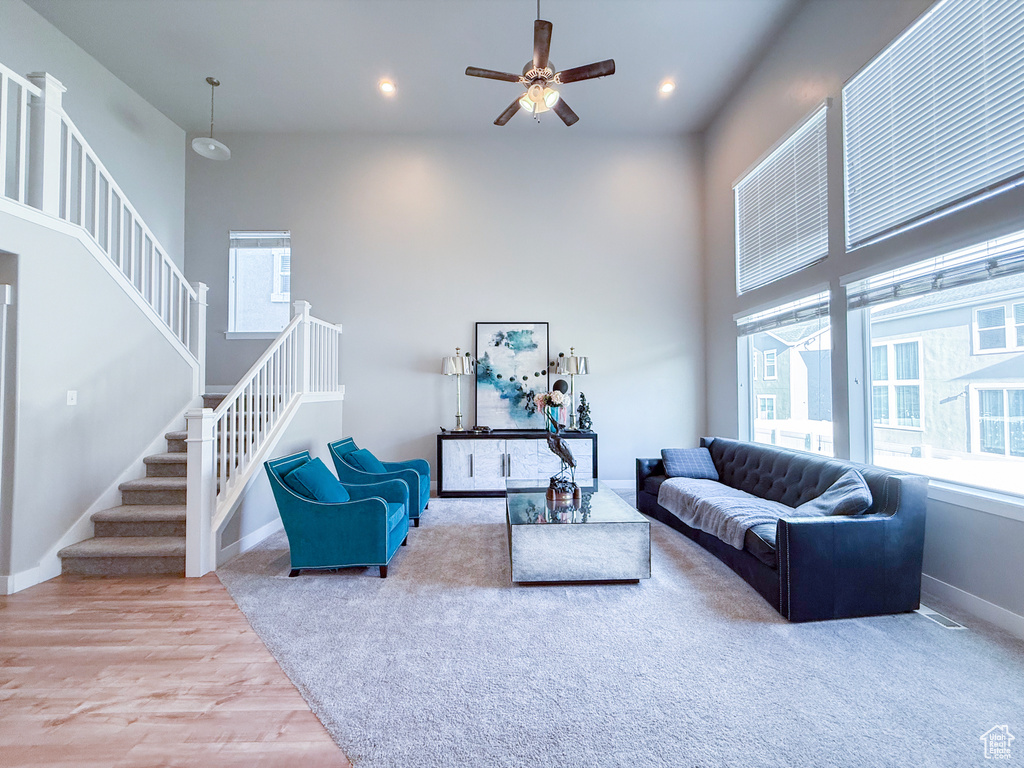 Living room featuring stairway, a ceiling fan, baseboards, wood finished floors, and recessed lighting
