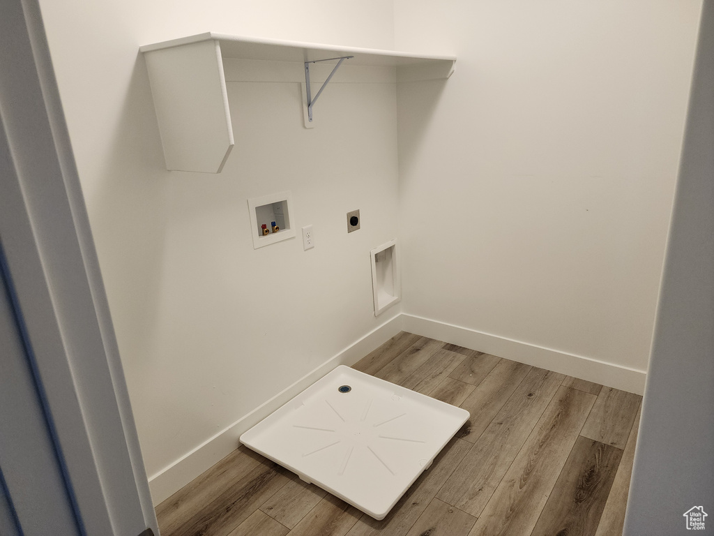 Laundry room featuring washer hookup, light wood-type flooring, baseboards, and electric dryer hookup