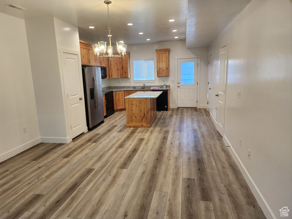 Kitchen featuring stainless steel fridge, a chandelier, recessed lighting, baseboards, and light wood-style flooring